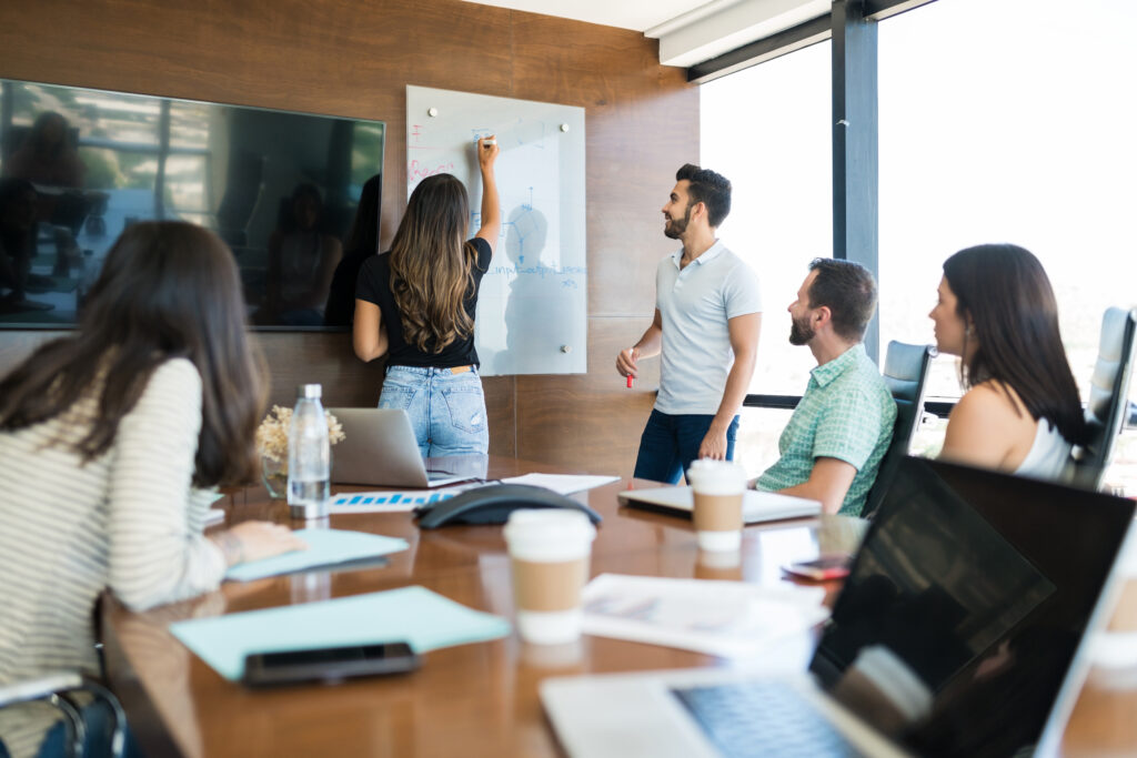 Équipe de direction en réunion de CODIR, échange autour d'un paperboard